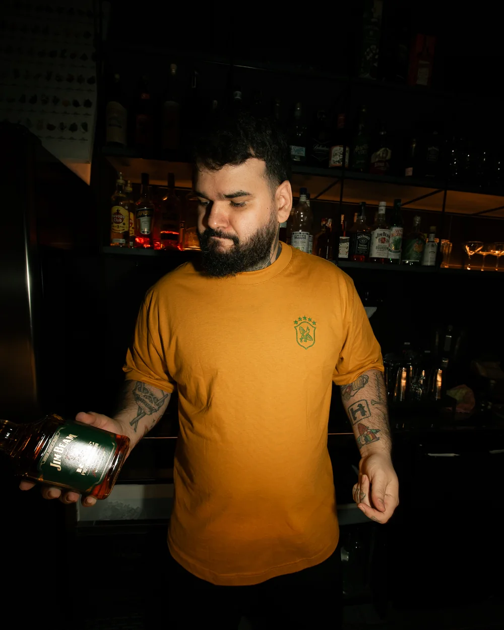 Bartender do Cuco vestindo a camiseta laranja de uniforme produzida pela Kanhouse