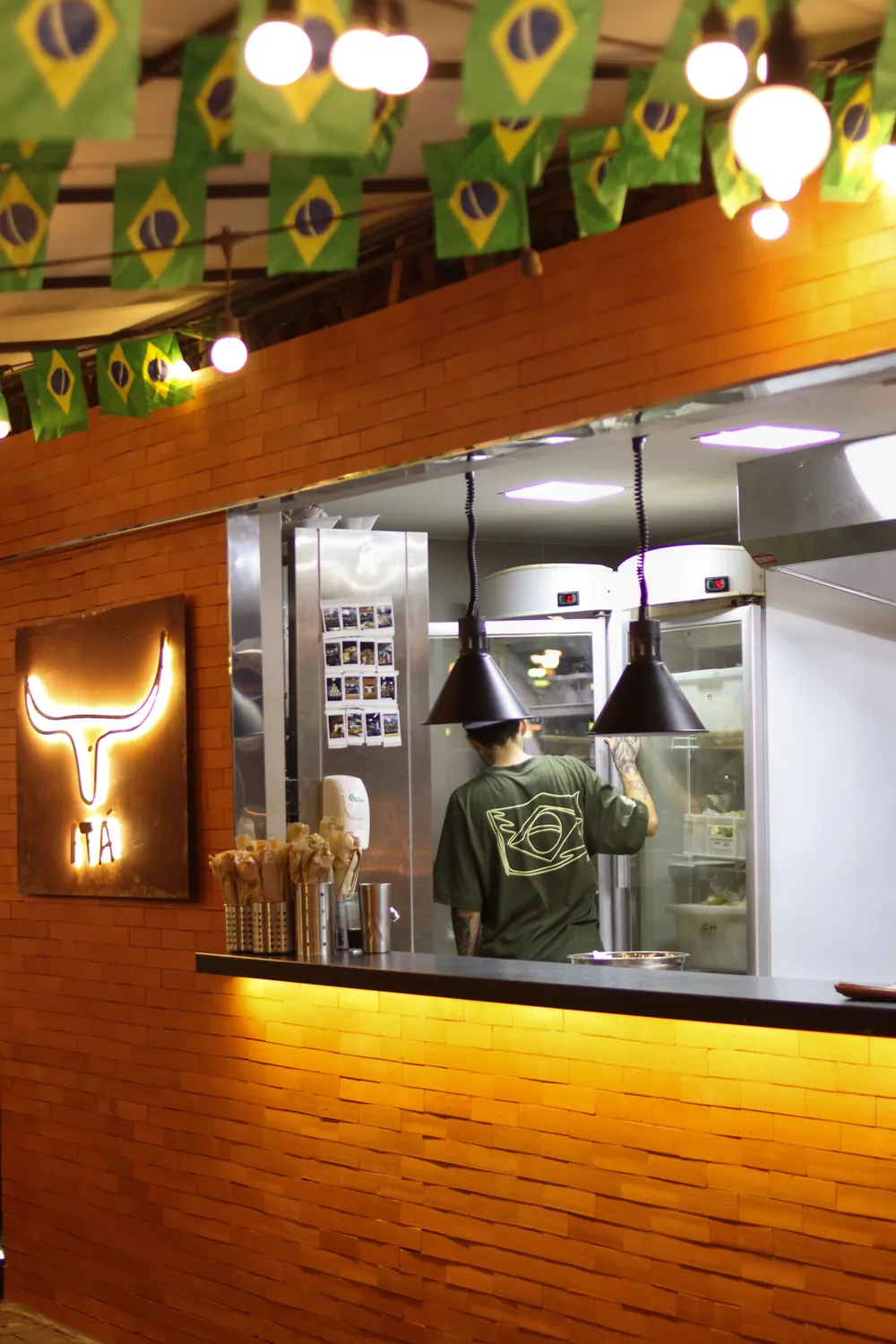 Fachada do restaurante Itá com logo de boi iluminado