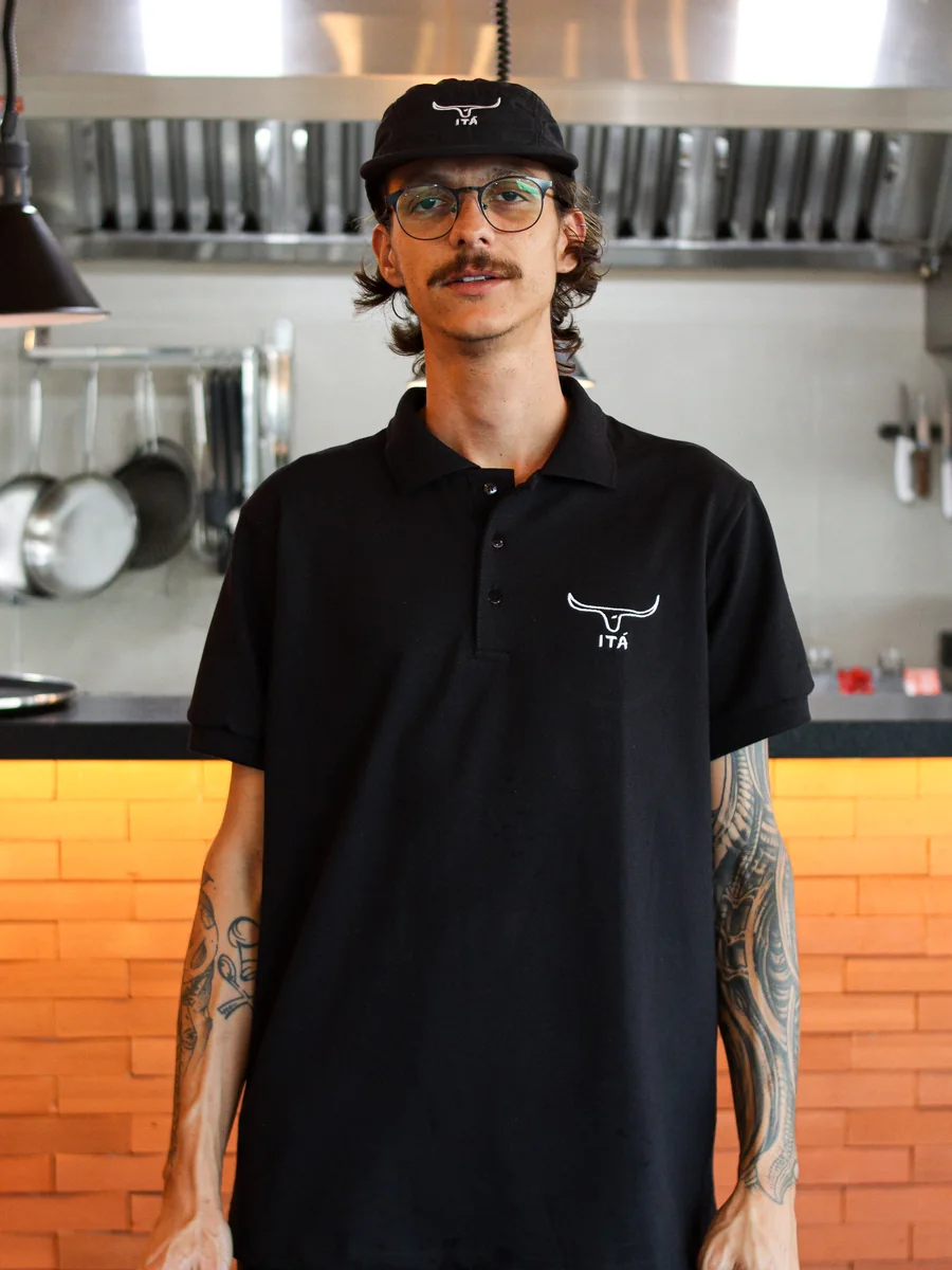 Polo preta de uniforme na cozinha do restaurante Itá